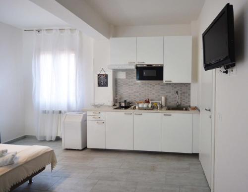 a kitchen with white cabinets and a tv in it at 4-Tourist House Bologna-Studio - Self check-in in Bologna