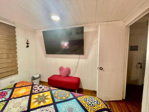 a bedroom with a bed and a red chair at Habitacion Deluxe, Wi-Fi, desayuno gratis y a minutos del crucero! in San Antonio