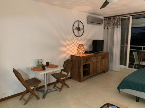 sala de estar con mesa y TV en la pared en Marigot, Studio front de mer vue exceptionnelle, en Marigot
