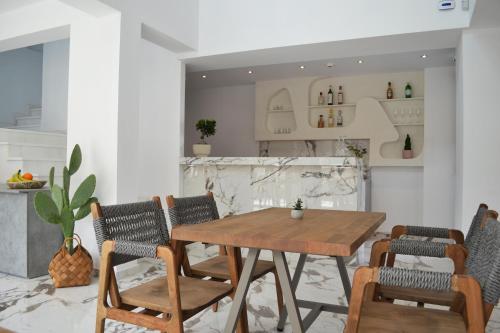 a dining room with a wooden table and chairs at IADES suites in Afitos
