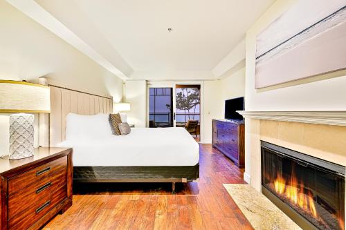 a bedroom with a bed and a fireplace at Cliff View II in Laguna Beach