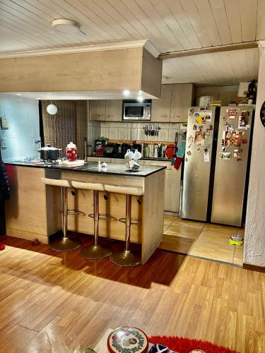 a kitchen with a counter and a refrigerator at Habitacion Deluxe, Wi-Fi, desayuno gratis y a minutos del crucero! in San Antonio