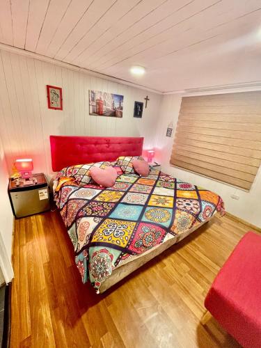 a bedroom with a large bed with a red head board at Habitacion Deluxe, Wi-Fi, desayuno gratis y a minutos del crucero! in San Antonio