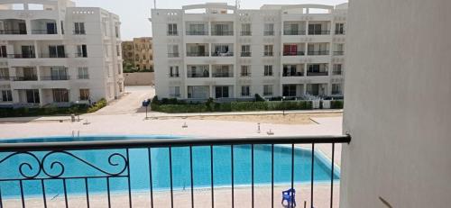 Palmera Beach Chalet - Families Only في العين السخنة: اطلالة من البلكونة على مبنى مع مسبح