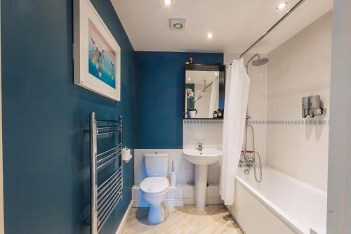 Baño azul con aseo y lavamanos en Beautiful Central Family Apartment for 6, en Londres