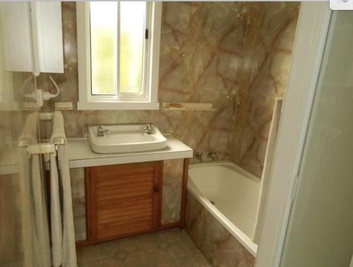 a bathroom with a sink and a bath tub at Maydena Chalet in Maydena