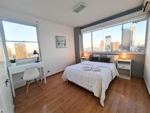 um quarto com uma cama grande e 2 janelas grandes em G&G Apartments - Obelisco River View em Buenos Aires