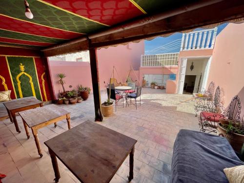 eine Terrasse mit Holztischen und Stühlen auf einer Terrasse in der Unterkunft Riad Dar Zayna in Essaouira