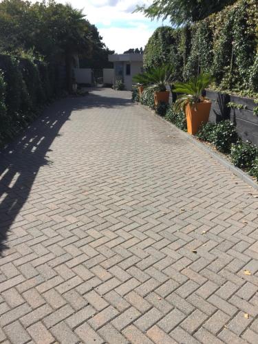 a brick driveway with trees and plants on the side at Kingsley Quarters in Cambridge