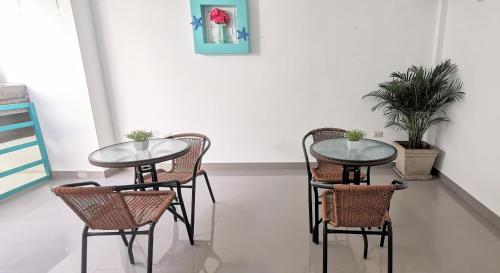 ein paar Tische und Stühle in einem Zimmer in der Unterkunft AQUAMARINE PARACAS Beach Hostal in Paracas