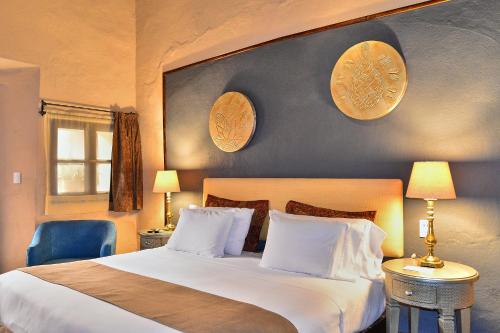 a bedroom with a large white bed with a blue wall at Hotel Mesones 49 in San Miguel de Allende