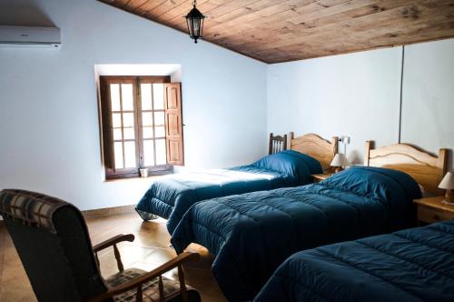a room with three beds and a window at Casa Rural El Milano in Bullas