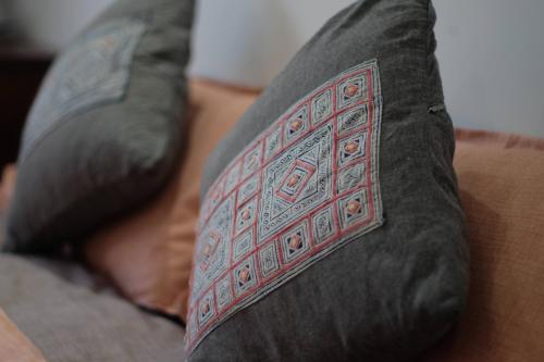 a pillow with a design on it sitting on a couch at La Sen-Thường Xuân in Thôn An Hòa