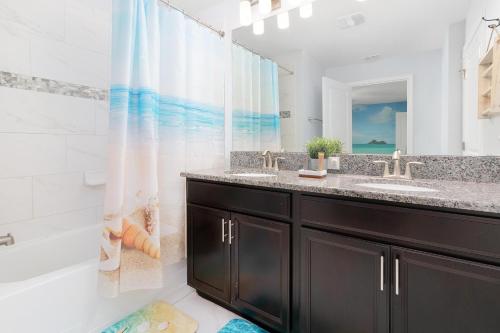 y baño con lavabo, bañera y ducha. en Storey Lake Home W Pool Mins To Disney 4br Waterpark, en Kissimmee