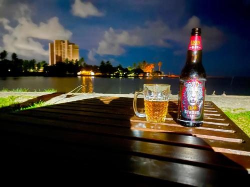 una botella de cerveza sentada en una mesa con un vaso en Maha Oya Lodge, en Wayikkal