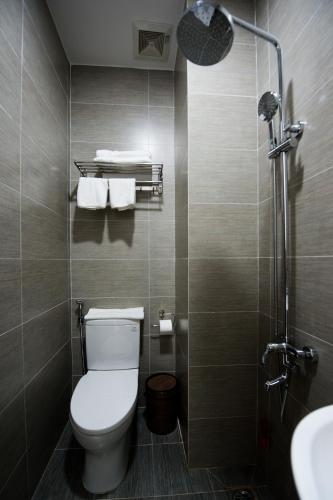 a small bathroom with a toilet and a shower at The White House in Ho Chi Minh City