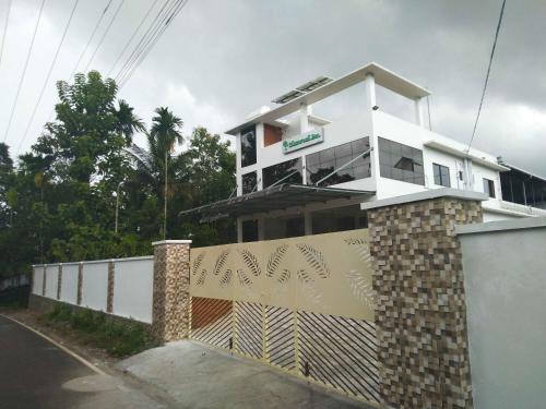 a white house with a fence in front of it at Shamrock Inn in Cochin