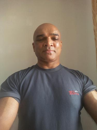 a man in a blue shirt with his eyes closed at Eco Village Yoga Home in Digana