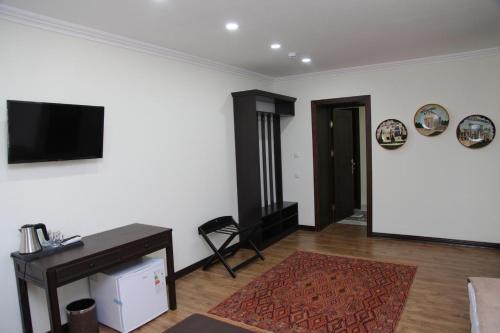 a living room with a flat screen tv on a wall at CRYSTAL HOTEL in Bukhara