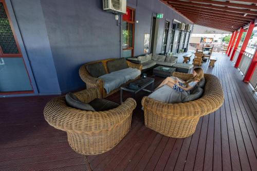 a woman sitting on a couch in a living room at The Jack Backpackers in Cairns