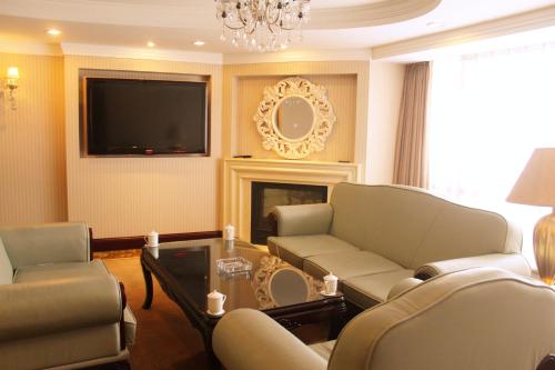 a living room with a couch and a tv at Beijing Continental Grand Hotel in Beijing