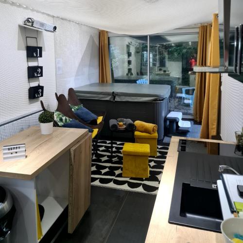 a living room with a bed and yellow chairs at loft SPA nature et détente in Messy