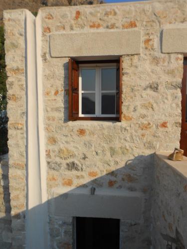 a stone building with a window and a concrete counter at villa Elpiniki Tilos in Megálon Choríon