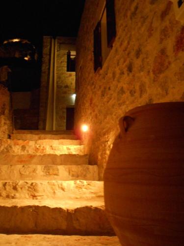 a vase sitting next to a stone building at night at villa Elpiniki Tilos in Megálon Choríon
