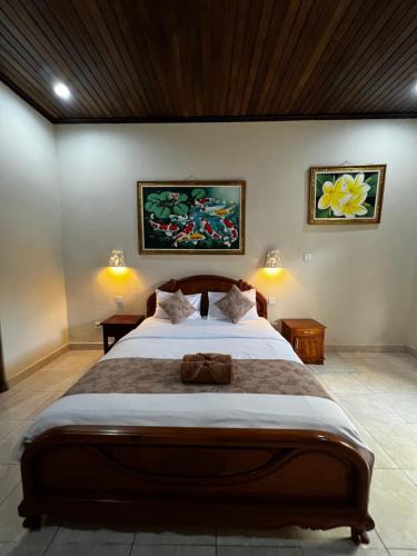 een slaapkamer met een groot bed en 2 lampen bij Nari Homestay in Canggu