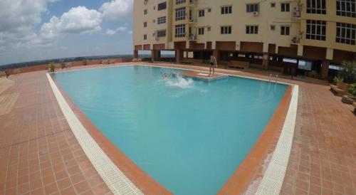 a large blue swimming pool in front of a building at Embun Sky Cottage - Kota Bharu, WIFI, 6 - 8 Pax in Kota Bharu