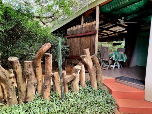 a wooden fence in front of a house at Lebombo Wattle Cottage - Forest 1 in Hluhluwe