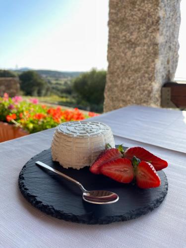 a cake on a plate with strawberries on a table at La Minditta in San Teodoro