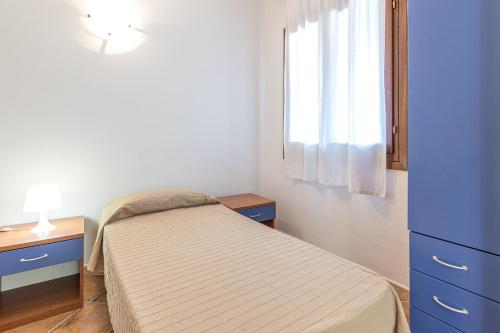 a small bedroom with a bed and a window at Le Dimore di Nettuno in Olbia