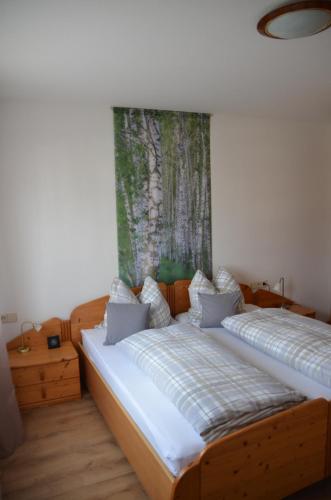 2 Betten in einem Zimmer mit Wandgemälde in der Unterkunft Ferienwohnung Fahrner in Baiersbronn