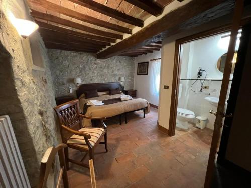 a bedroom with a bed and a bathroom with a toilet at Tenuta Decimo - Villa Dini in San Gimignano