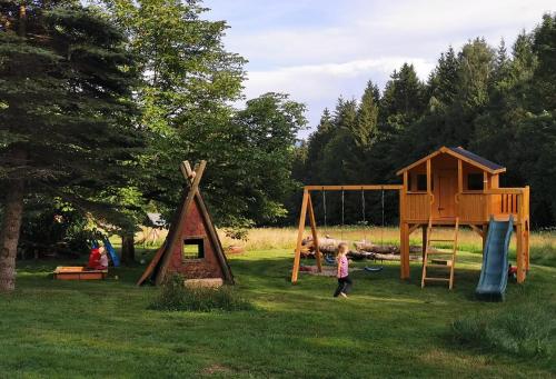 a child standing in the grass near a playground at Altes Forsthaus Bodenmais in Bodenmais