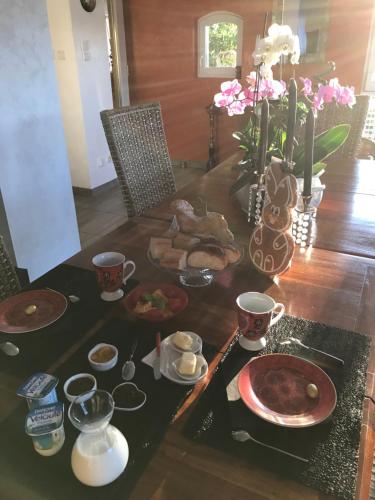 a dining room table with food and drinks on it at Le Clos d'Auré. in Oberhaslach