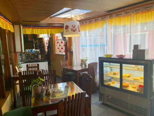 a dining room with a table and a fish tank at Auspiscious Him View Hotel in McLeod Ganj