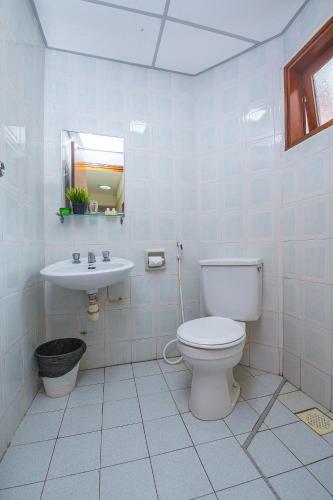 a white bathroom with a toilet and a sink at Kijal Permai Apartment in Kijal
