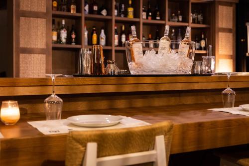a bar with a table with a plate and glasses at Skiathos Thalassa, Philian Hotels and Resorts in Skiathos Town