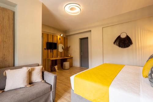 a bedroom with a bed and a couch at Skiathos Thalassa, Philian Hotels and Resorts in Skiathos Town
