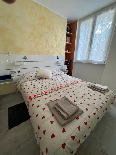 1 dormitorio con 1 cama con manta de corazón roja en Campanino Baby en Chiavari