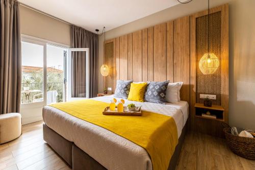 a bedroom with a large bed with a yellow blanket at Skiathos Thalassa, Philian Hotels and Resorts in Skiathos