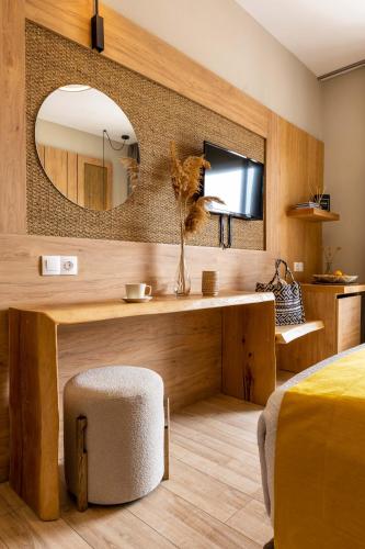 a bedroom with a table with a mirror and a chair at Skiathos Thalassa, Philian Hotels and Resorts in Skiathos Town