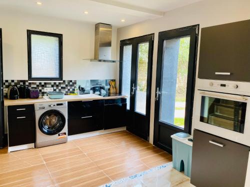a kitchen with a washer and a washing machine in it at Duplex climatisé avec une terrasse sur jardin in Montmorency