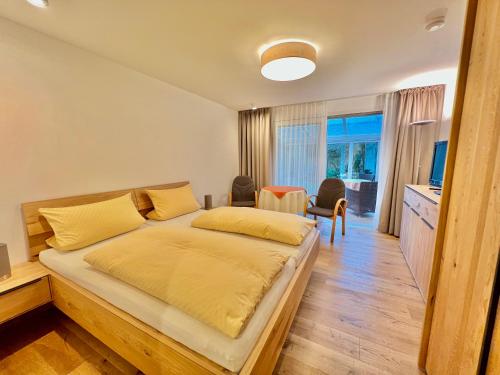 a bedroom with a bed and a table and chairs at ADORIS APPARTEMENTS im Lotzbeckpark am See "nachhaltiges Wohnen in Lindau" in Lindau