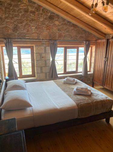 a large bed in a room with windows at Angelic in the mountains in Kaisárion