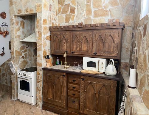 a kitchen with wooden cabinets and a stove top oven at SUPERB - Medieval apartment in Kutná Hora