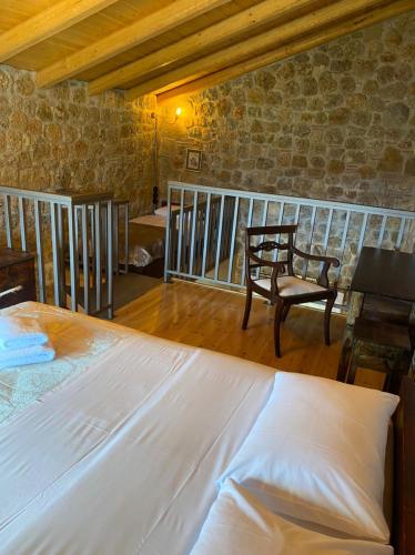 a bedroom with a large white bed and a chair at Angelic in the mountains in Kaisárion