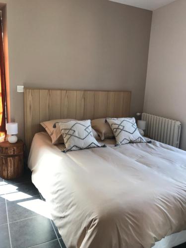 a bed with white sheets and pillows in a bedroom at L'Estampille in Saint-Vidal